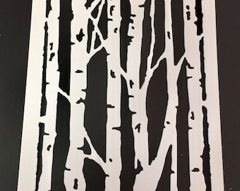May include: A white stencil featuring a birch tree design. The stencil has a rectangular shape with cut-out tree trunks and branches, creating a negative space effect. The design is suitable for various craft projects.