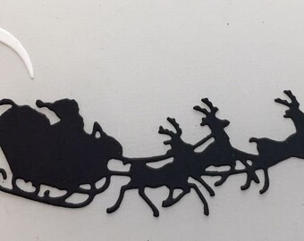 May include: A black silhouette of Santa Claus in a sleigh pulled by reindeer, with a white crescent moon in the background. The image is a festive holiday design, perfect for Christmas decorations or crafts.