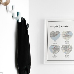 K&ouml;nnte beinhalten: Ein wei&szlig;er gerahmter Druck mit einer Karte einer Stadt in Form eines Herzens. Der Druck enth&auml;lt den Text "Steve & Amanda" oben und vier herzf&ouml;rmige Karten mit dem Text "Hello", "Will You?", "I Do" und "First Home" darunter.