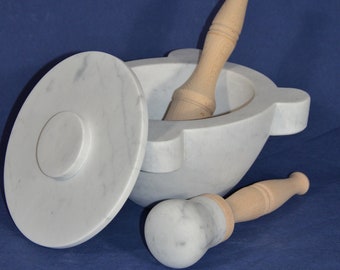 Peut inclure: Ensemble mortier et pilon en marbre blanc avec un manche en bois. Le mortier a un couvercle et le pilon a une tête arrondie.