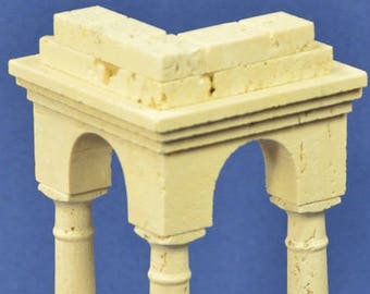 May include: A small, off-white architectural model with three columns supporting an arched roof. The model has a square base and is made of a textured material, possibly stone or plaster. The background is a solid blue.