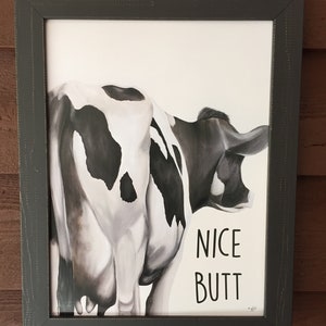 May include: A framed black and white illustration of a cow's rear end with the text "NICE BUTT" printed below.