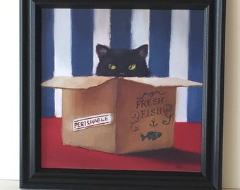 May include: Framed artwork featuring a black cat peeking out of a cardboard box. The box is labeled "Fresh Fish" with an anchor and fish illustration. The background has blue and white stripes, and the box has a "Perishable" sticker.