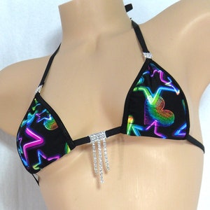 May include: Black bikini top with a neon rainbow heart and lightning bolt print. The top has a rhinestone strap and a rhinestone fringe.