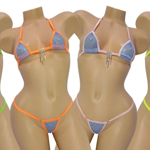 May include: Four colorful bikinis on mannequins. Each bikini features a halter top and a thong bottom. The colors include green, orange, pink, and yellow, with silver accents and a mesh design. The bikinis are displayed on mannequins.