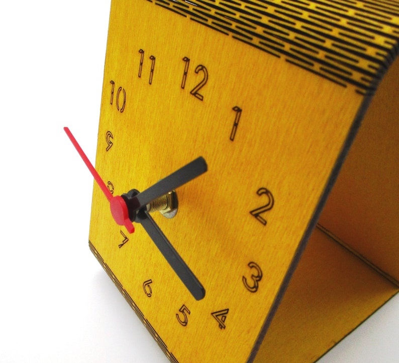 May include: A yellow wooden clock with black numbers and hands. The clock has a red second hand and is set to 10:10.