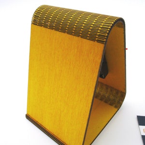 May include: A yellow wooden stand with a geometric pattern on the top. The stand is made of plywood and has a natural wood finish.
