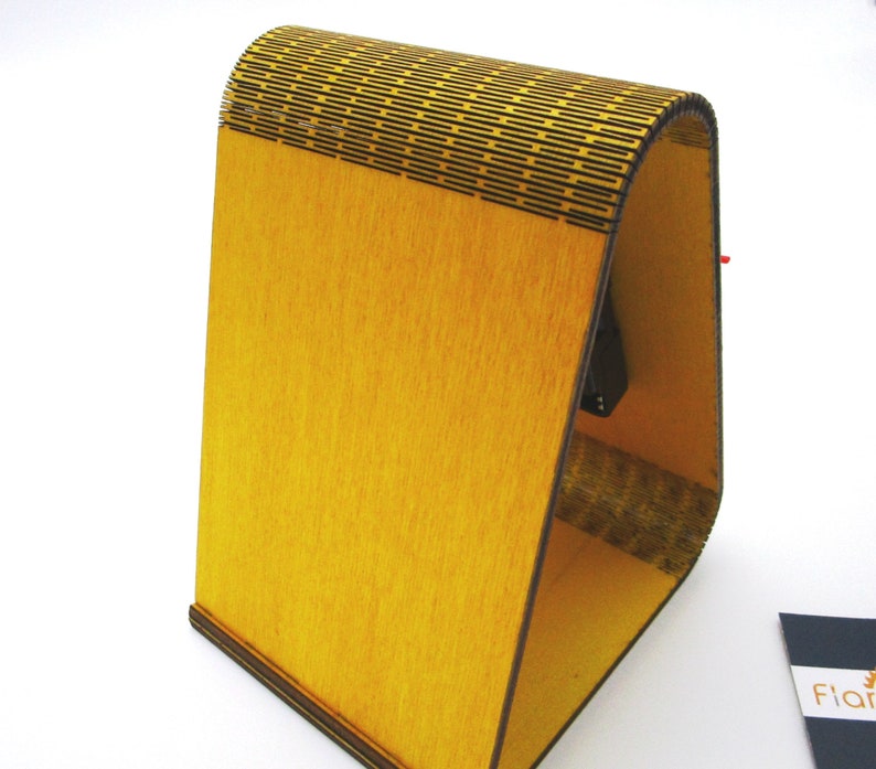 May include: A yellow wooden stand with a geometric pattern on the top. The stand is made of plywood and has a natural wood finish.