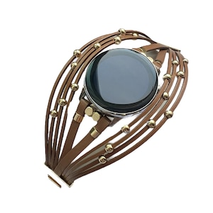 May include: A brown leather watch band with gold beads. The band is made of multiple strands of leather and has a clasp closure.