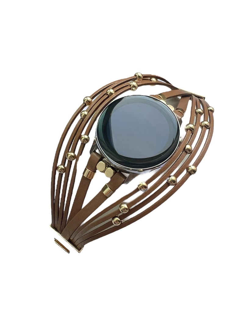 May include: A brown leather watch band with gold beads. The band is made of multiple strands of leather and has a clasp closure.