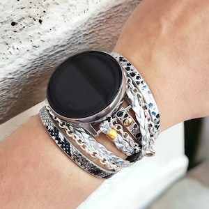 May include: A silver smartwatch with a black face and a multi-layered band. The band is made of braided leather, chain, and a snakeskin pattern.