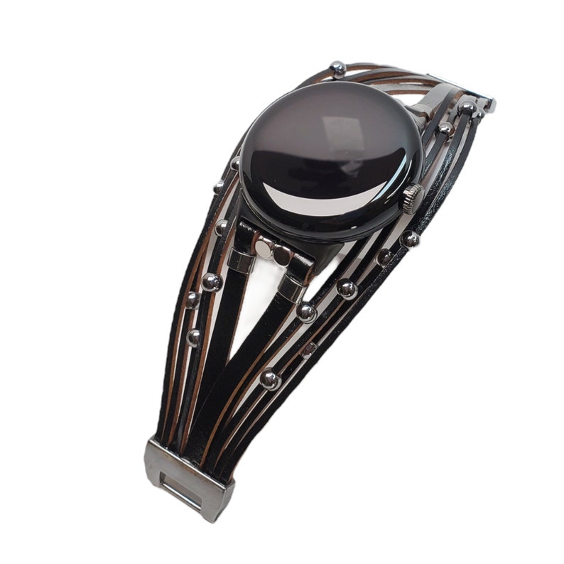 May include: Black leather watch bracelet with silver accents and a round black face.