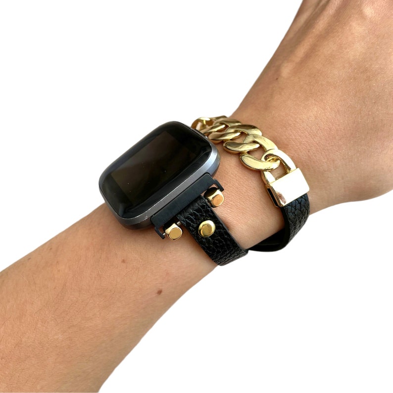 Peut inclure: Un bracelet de montre en cuir noir avec des accents dor&eacute;s et un bracelet &agrave; maillons dor&eacute;s.
