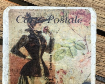 May include: A vintage postcard with a woman in a black dress and hat, holding a flower. The postcard has a floral design and the text "Carte Postale" in black.