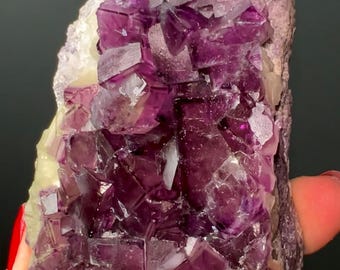 May include: A cluster of purple fluorite crystals with a light yellow base. The crystals are sharp and well-defined, with a glassy luster.