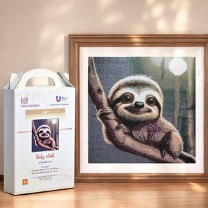 May include: A hand embroidery kit featuring a baby sloth hanging from a branch. The kit includes 30 colours, 170 x 170 stitches, and a 10 cm x 10 cm canvas. The image is in a wooden frame.