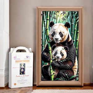 May include: A framed painting of two pandas in a bamboo forest. The mother panda is holding a bamboo stalk in her mouth and the baby panda is holding a bamboo stalk in its paws. The painting is in a brown frame.
