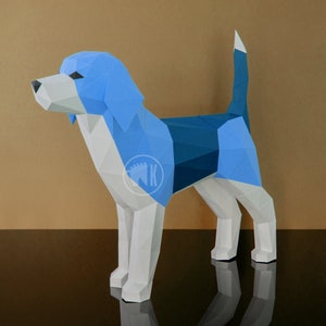 May include: A blue and white papercraft model of a beagle dog. The dog is standing on a black surface with a brown background.