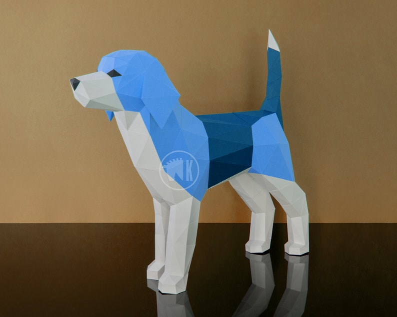 May include: A blue and white papercraft model of a beagle dog. The dog is standing on a black surface with a brown background.