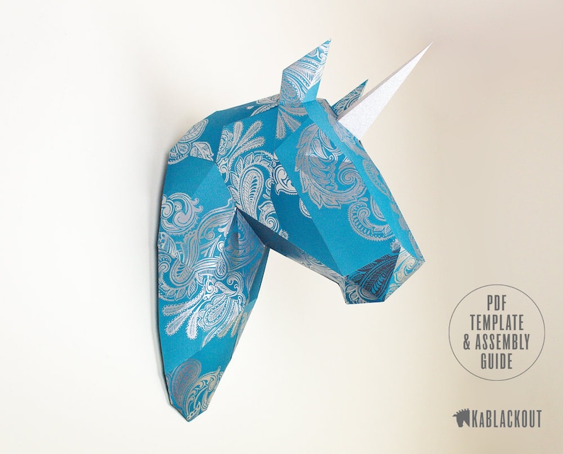 May include: A blue and silver patterned papercraft unicorn head wall decor. The unicorn has a white horn and is made of folded paper. PDF Template & Assembly Guide.