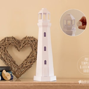 Puede incluir: Modelo de faro de papel blanco con una corona en forma de corazón y libros en un estante de madera. El texto "PDF TEMPLATE & ASSEMBLY GUIDE" es visible en la imagen.