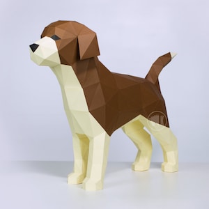 May include: A brown and white papercraft model of a beagle dog. The dog is standing on a white surface and is looking to the left. The model is made of folded paper and has a realistic appearance.