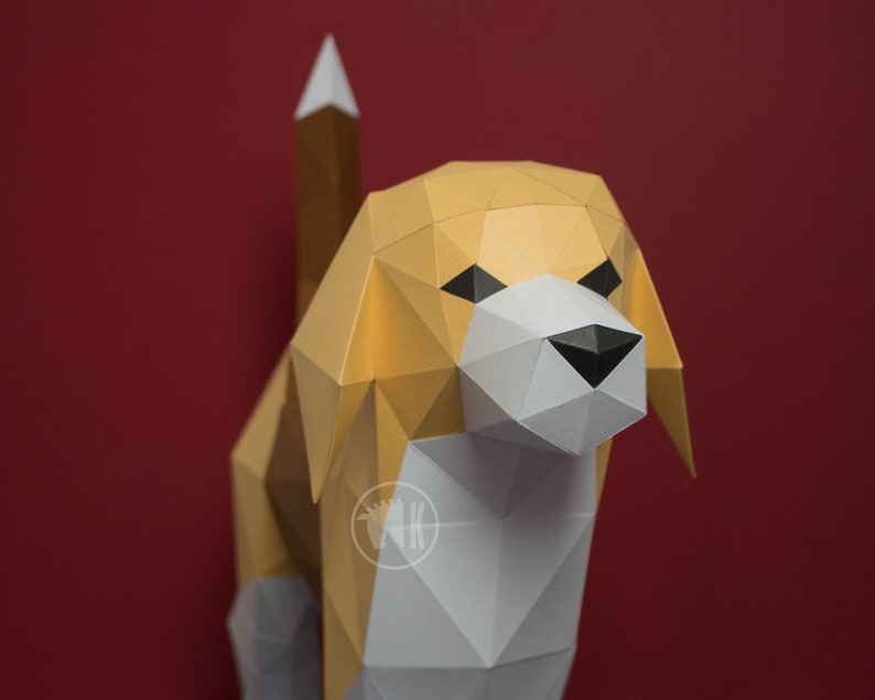 May include: A papercraft model of a beagle dog. The dog is made of white, brown, and black paper and has a realistic appearance. The dog is standing on a red background.