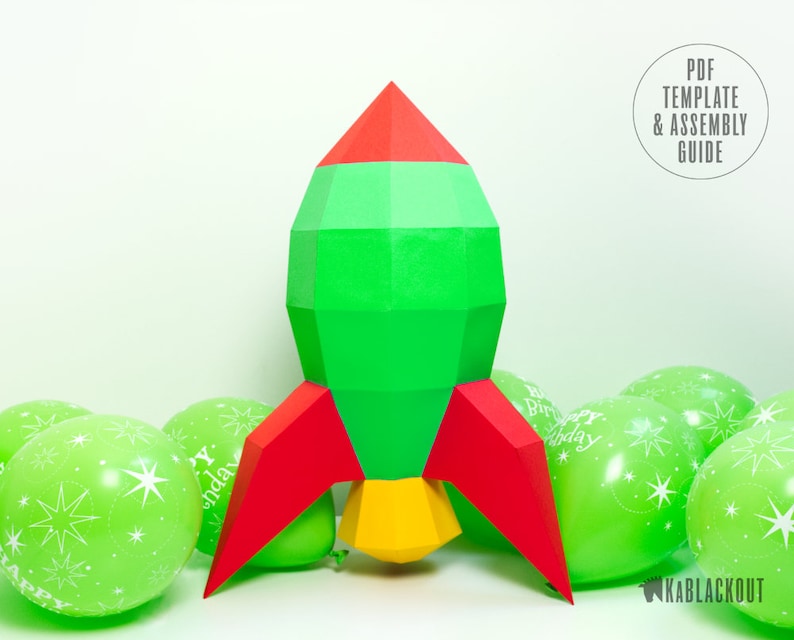 May include: A green, red and yellow paper rocket with a red and yellow flame. The rocket is surrounded by green balloons with white stars and the text "Happy Birthday".
