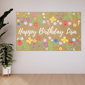 May include: A rectangular banner with a kraft paper background, adorned with colorful flowers and green leaves. The words "Happy Birthday Lisa" are written in white script across the center. The floral design includes red, yellow, blue, and purple flowers.