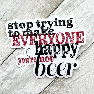 May include: White sticker with black and red text that reads "stop trying to make everyone happy you're not beer".