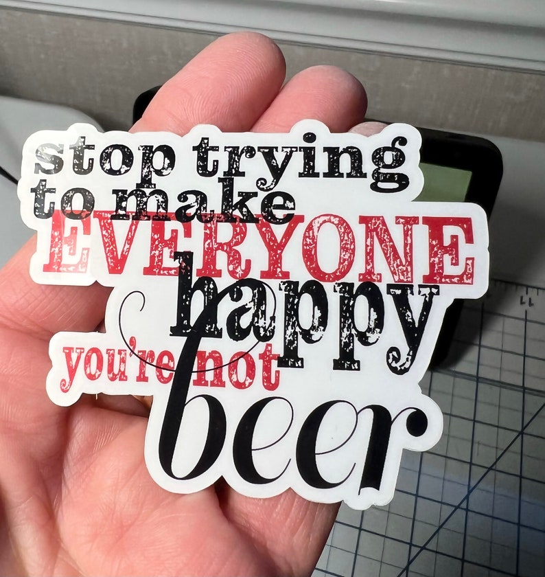 May include: A white sticker with black and red text that reads "stop trying to make everyone happy you're not beer".