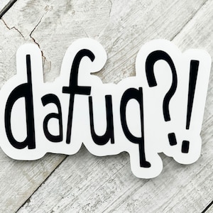 May include: A white sticker with black text that reads "dafuq?!" The sticker is on a light wood background.