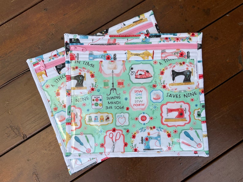 K&ouml;nnte beinhalten: Drei Rei&szlig;verschlusstaschen zum Thema N&auml;hen. Die Taschen haben einen hellgr&uuml;nen Hintergrund mit N&auml;hmaschinenillustrationen, floralen Akzenten und dem Text "A Stitch in Time Saves Nine". Die Rei&szlig;verschl&uuml;sse sind rosa.