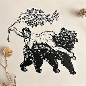 May include: Black and white woodcut print of a woman riding a bear. The woman is holding a branch of flowers above her head. The bear is facing to the right.