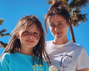 May include: Two girls wearing blue and white t-shirts with ice cream graphics and the text "Ice Cream Fan Club". The girl on the left is holding a chocolate ice cream cone.
