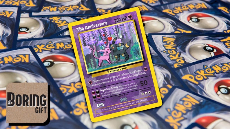 May include: A purple and yellow Pokemon card featuring a pink and black Pokemon with the text "The Anniversary" and "I choose you!" The card has a background of a purple forest with hearts.