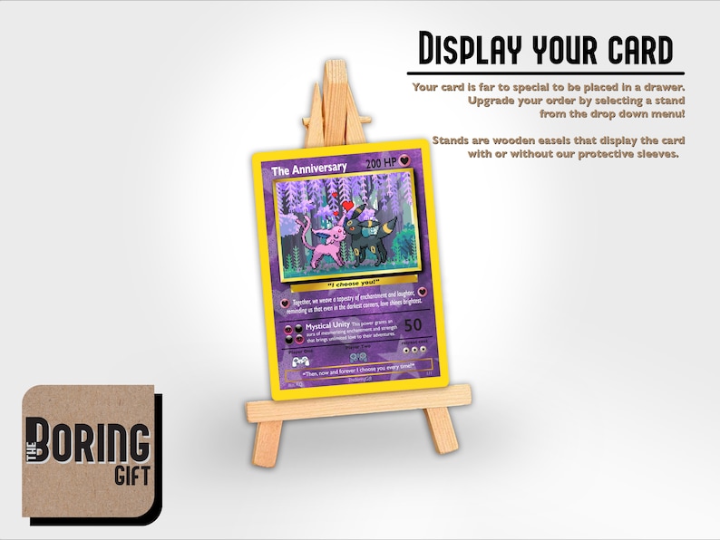 May include: A purple and yellow Pokemon card featuring a pink and black Pokemon with the text "The Anniversary 200 HP". The card is displayed on a wooden easel.