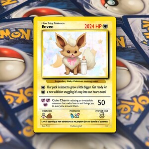 May include: A yellow Pokemon card featuring Eevee, a baby Pokemon with a pink bow and a bottle. The card has a light blue background with stars and moons. The text on the card reads "New Baby Pokemon Eevee 2024 HP".