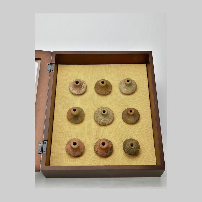 Clay spindle whorls being displayed in a wooden case.