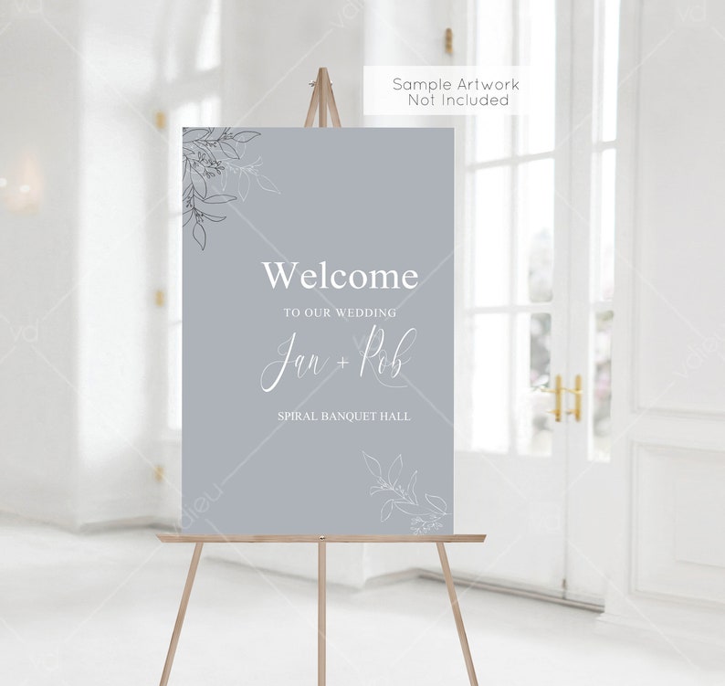 May include: A light blue welcome sign with white text and floral designs. The sign reads "Welcome to our wedding Jan + Rob Spiral Banquet Hall".