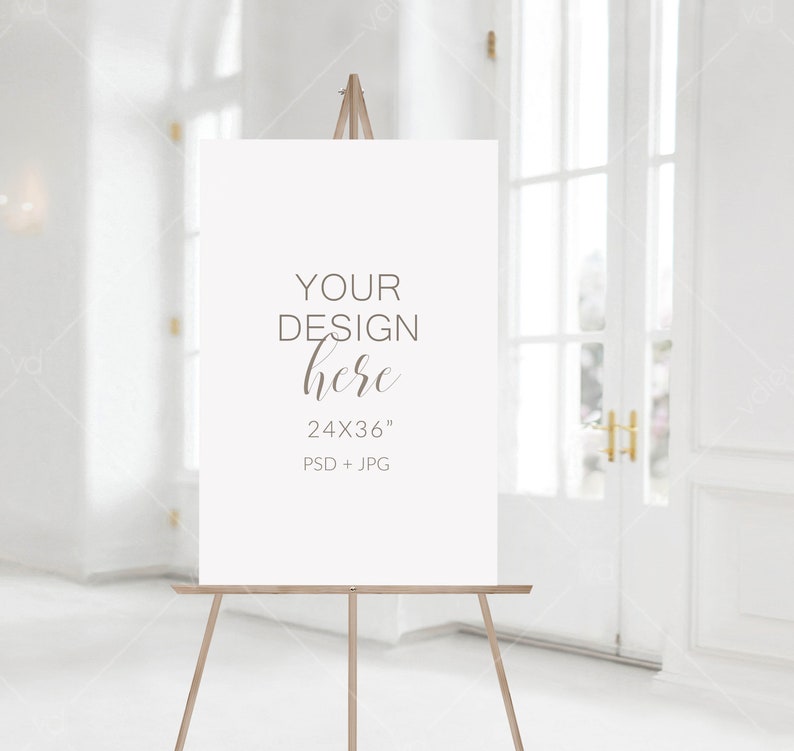 May include: A white canvas sign on an easel with the text "YOUR DESIGN here 24X36" PSD + JPG" in brown text.