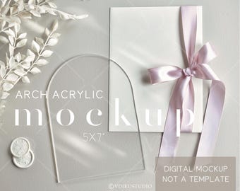 May include: A clear acrylic arch mockup with the text "ARCH ACRYLIC mock 5x7" and a white card tied with a light pink ribbon. Two white wax seals and a sprig of white leaves are also present.