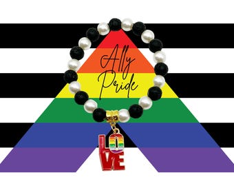Può includere: Un braccialetto di perline che alterna pietre laviche nere porose e perline bianche lisce. Un distanziatore dorato sostiene un ciondolo a forma della parola LOVE, con la lettera O decorata nei colori dell'arcobaleno.