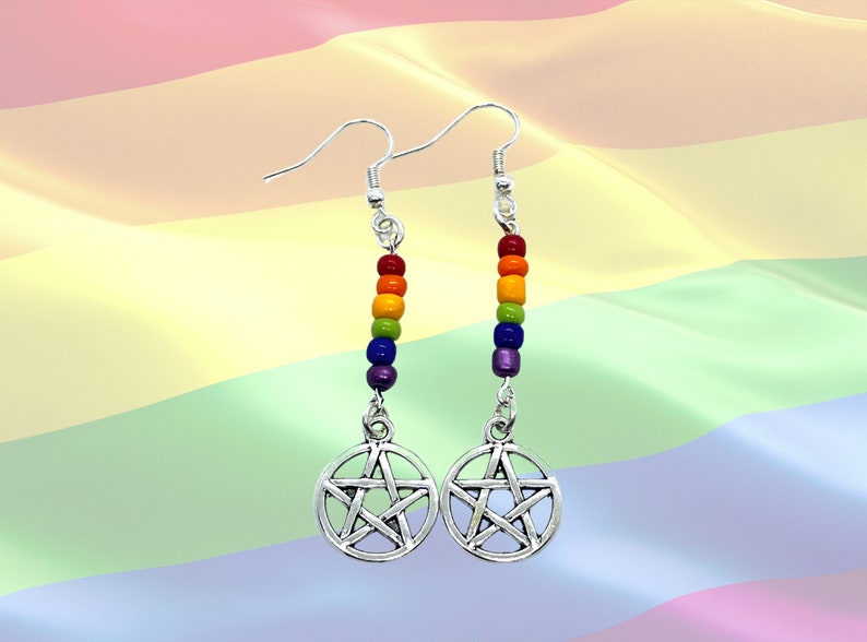 May include: A pair of silver-toned drop earrings featuring a circular pentacle charm suspended from a vertical row of five small, multi-coloured beads in red, orange, yellow, green, blue, and purple, attached to silver-toned earring hooks.
