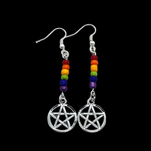 May include: A pair of silver-toned drop earrings featuring a circular pentagram charm suspended from a vertical row of five small, multicoloured beads in red, orange, yellow, green, blue, and purple, attached to silver-toned ear hooks.