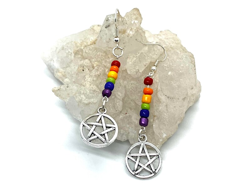May include: A pair of drop earrings featuring silver-toned pentacle charms suspended from vertical rows of small, multi-coloured beads in red, orange, yellow, green, blue, and purple, attached to standard silver-toned metal earring hooks.