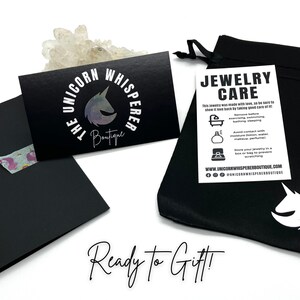 A black jewelry pouch with a white unicorn logo. Ready for gifting!