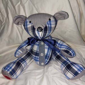May include: A handmade teddy bear made from blue and white plaid fabric. The bear has a gray face and a blue satin bow tie.