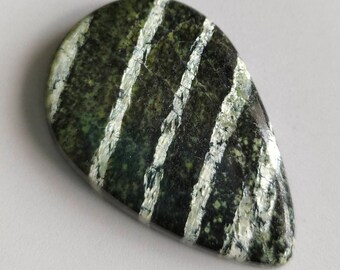 Puede incluir: Una piedra preciosa cabujón de forma de lágrima, rayada de verde y blanco.