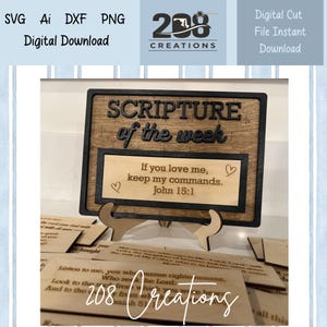 May include: Wooden sign featuring the text "SCRIPTURE of the week" and a Bible verse. The sign is brown with black lettering and a black border. The sign is displayed on a wooden stand. Digital download.